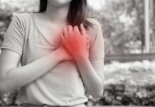 Woman holding her chest in pain outdoors