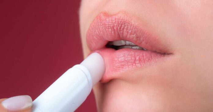Close-up of a person applying lip balm to their lips