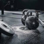Dumbbell Racks: Hidden Gym Hazard? Kettlebells and weights on a gym floor with chalk dust