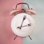 Boy Kibble Craze: The Protein Shortcut? An alarm clock with a plate and two forks arranged in a creative design