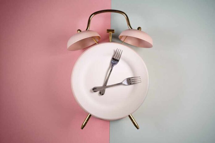 An alarm clock with a plate and two forks arranged in a creative design