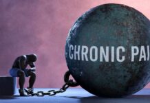 A figure representing chronic pain, sitting beside a large ball labeled 'CHRONIC PAIN' chained to their body