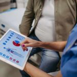 AI’s Role in Spotting Early Aging Nurse showing a patient health data on a tablet