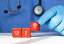Pancreatic Cancer Detection Breakthrough A doctor's gloved hand placing red blocks with health symbols on a table