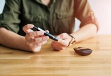 Person using a blood glucose meter and a pen device for diabetes management