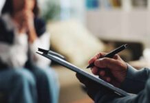 The Hidden Shield Against Anxiety A therapist taking notes during a session with a client in the background
