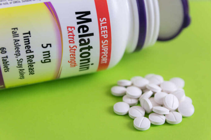 shutterstock1079372021jpg Bottle of melatonin tablets with some pills spilled on a green surface