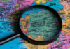 A magnifying glass focusing on the Democratic Republic of the Congo on a colorful map of Africa