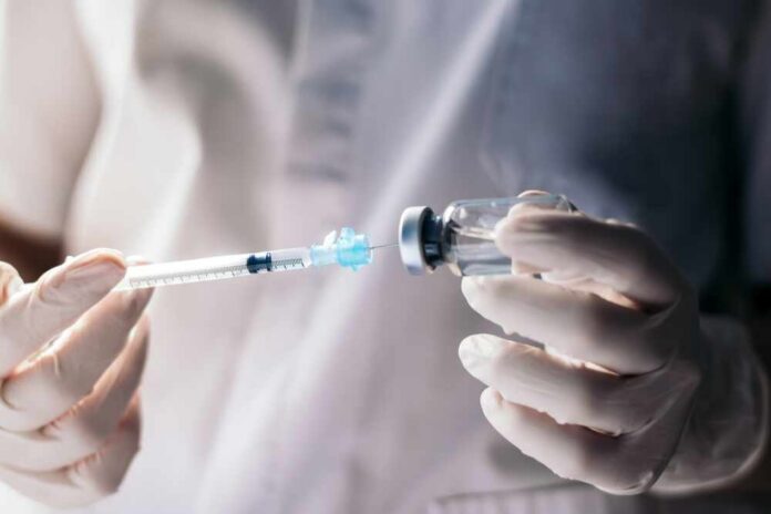 Injecting,Injection,Vaccine,Vaccination,Medicine,Against,Covid-19,Into,A,Syringe. A healthcare professional preparing a syringe from a vial
