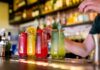 A bartender preparing colorful cocktails at a bar