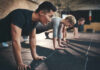 Group of individuals performing push-ups in a gym