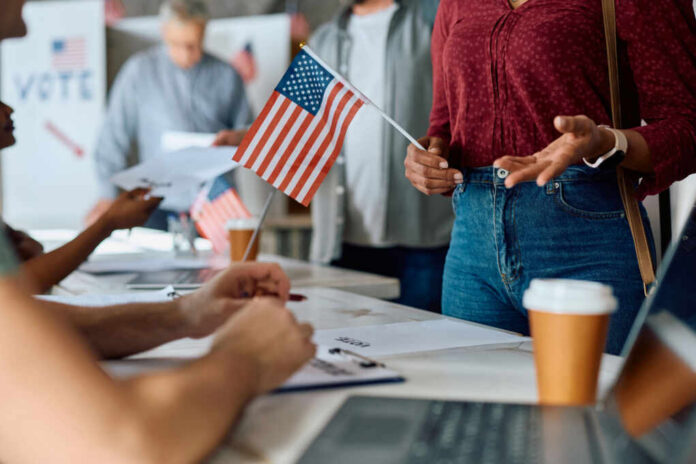 People participating in a voting event with American flags and paperwork