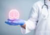 A medical professional holding a glowing digital brain illustration in their hand