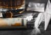 Meth’s Shocking Link To HIV A close-up of a syringe, pills, and a glass of alcohol on a dark surface