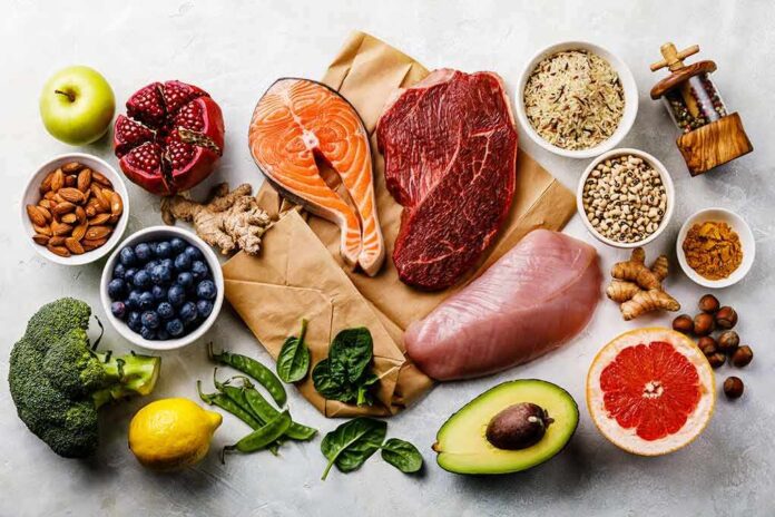 Assorted healthy foods with salmon, beef, chicken, fruits, vegetables, nuts, and grains