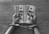 Financial Grip, Toxic Trap: Why Money Stress Hits So Hard Hands in handcuffs holding stacks of cash