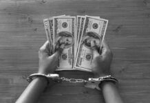 Financial Grip, Toxic Trap: Why Money Stress Hits So Hard Hands in handcuffs holding stacks of cash