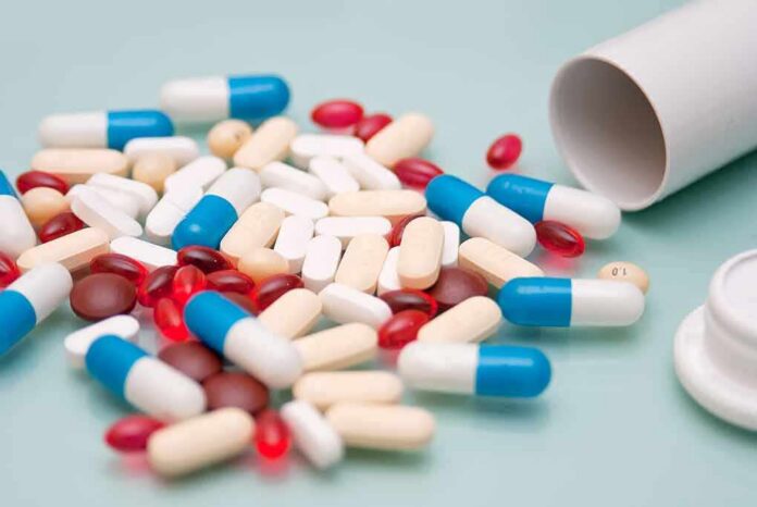 shutterstock_1925688692 Assorted pills and capsules spilled from a bottle