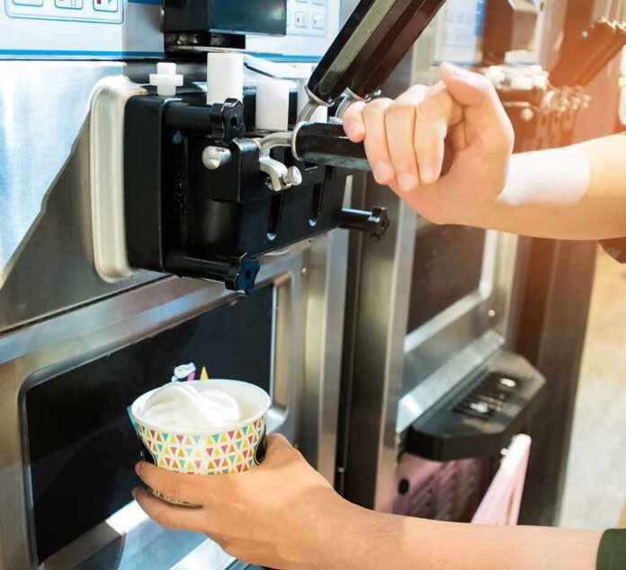 soft serve machine dispensing ice cream into a paper cup