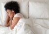 Woman sleeping on white bedding