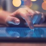 Hand tapping a tablet screen