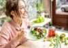 Woman eating a fresh salad at a bright cafe