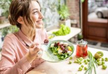 Woman eating a fresh salad at a bright cafe