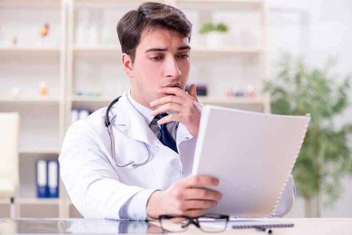 Doctor reviewing a file at a desk