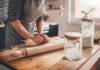 Person kneading dough on a wooden kitchen counter