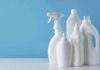 White plastic cleaning bottles against a blue background