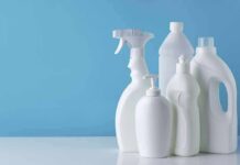White plastic cleaning bottles against a blue background
