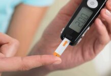 person using a blood glucose meter with a test strip