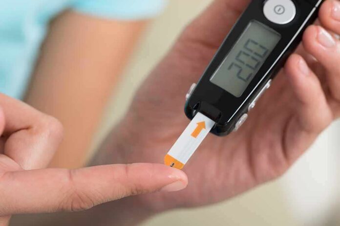 person using a blood glucose meter with a test strip