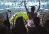 Fans celebrate in a packed stadium with confetti falling