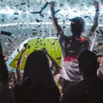 Fans celebrate in a packed stadium with confetti falling