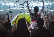 Fans celebrate in a packed stadium with confetti falling