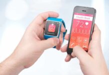 Obsessed With Your Sleep Scores? Bad Bet hands holding a smartwatch and a smartphone with health app