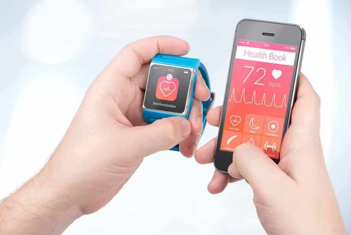 1783889002961-vz65uc-shutterstock-188507768 hands holding a smartwatch and a smartphone with health app