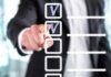 person in suit pointing at a digital checklist