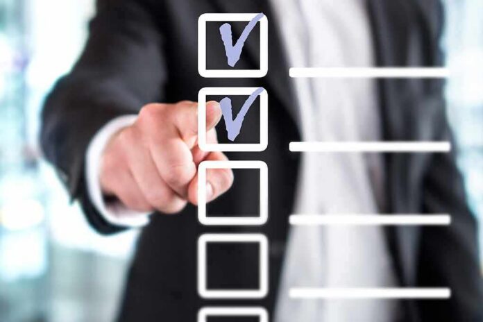 shutterstock_1053842837 person in suit pointing at a digital checklist