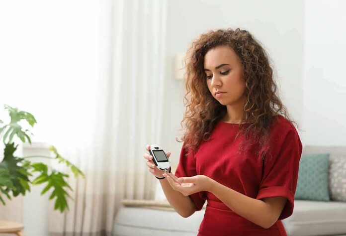 Woman using a blood glucose meter at home