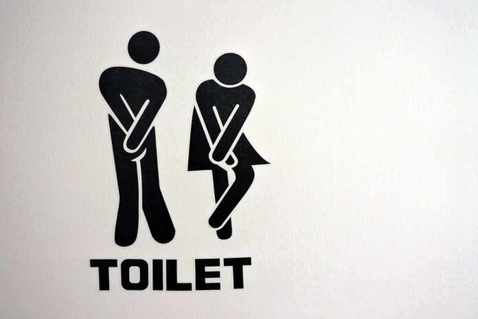 toilet sign with two figures crossing legs