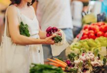 Woman selecting fresh vegetables at a farmers market stall