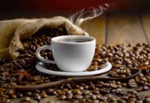 Effect of Coffee Aroma on your Brain steaming cup of coffee among roasted beans