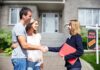 Homebuyers shaking hands with real estate agent outside house