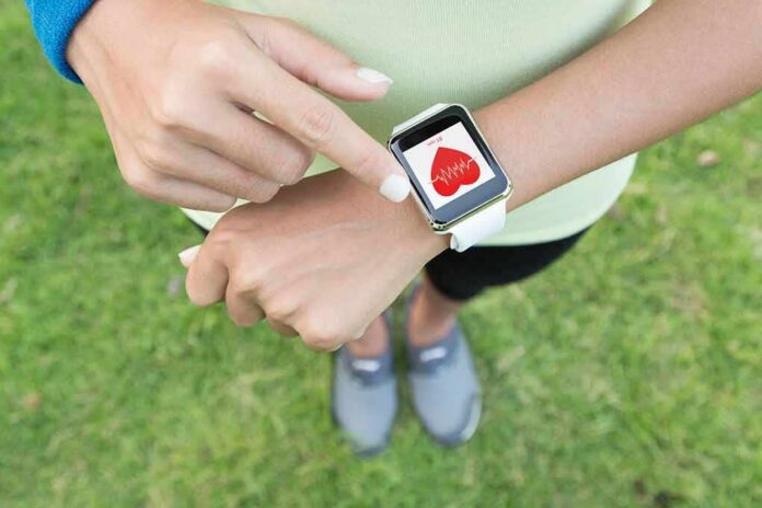 Person checking smartwatch heart rate on wrist outdoors
