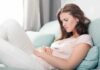 The Six Patterns of Constipation and How to Fix Them Woman lying on couch holding her stomach