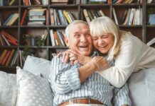 Aging Ambush: Why Men’s Defenses Fade Early Older couple hugging and laughing on a couch
