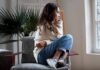 Woman sitting curled up on a chair looking out a window
