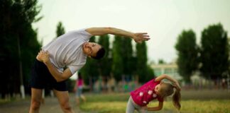 Man and young girl stretching outdoors